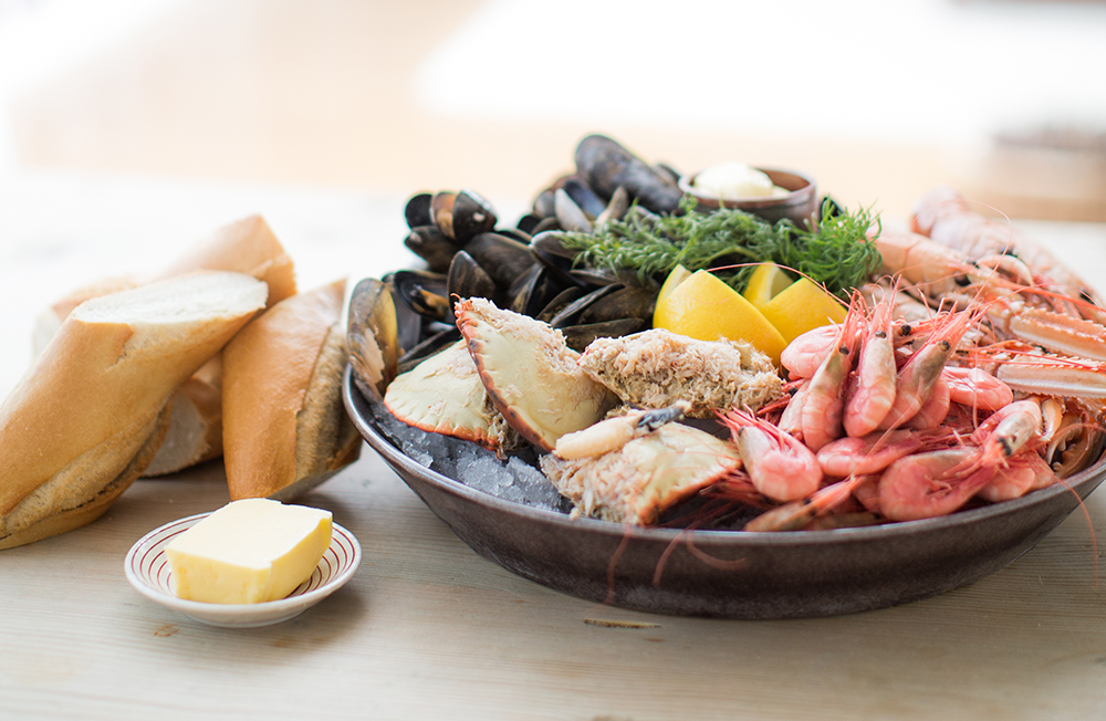Mussels, shrimps, crab on a plate with bread on the side